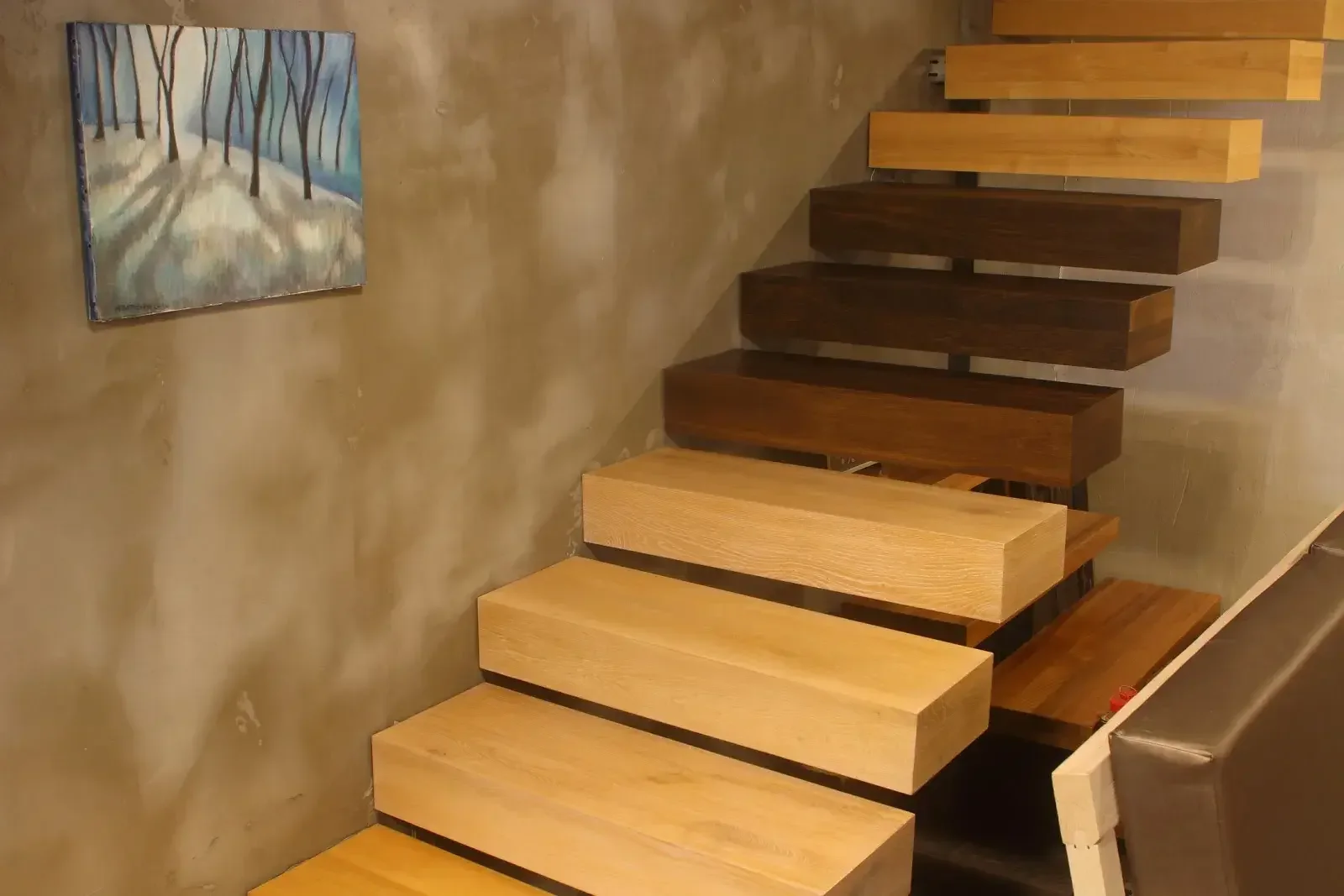 Escalera de roble macizo con barra de acero en un interior luminoso